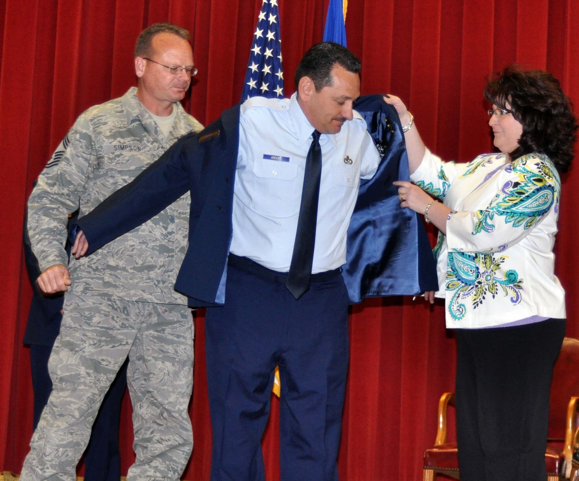 Newly promoted Chief Master Sgt. Christopher N. Greene puts on his new stripes with assistance from his wife, Mrs. Debi Greene, and his fellow Chief, Chief Master Sgt. Steven Simpson, February 13, 2011.  (U.S. Air Force photo/Master Sgt. Linda Welz)