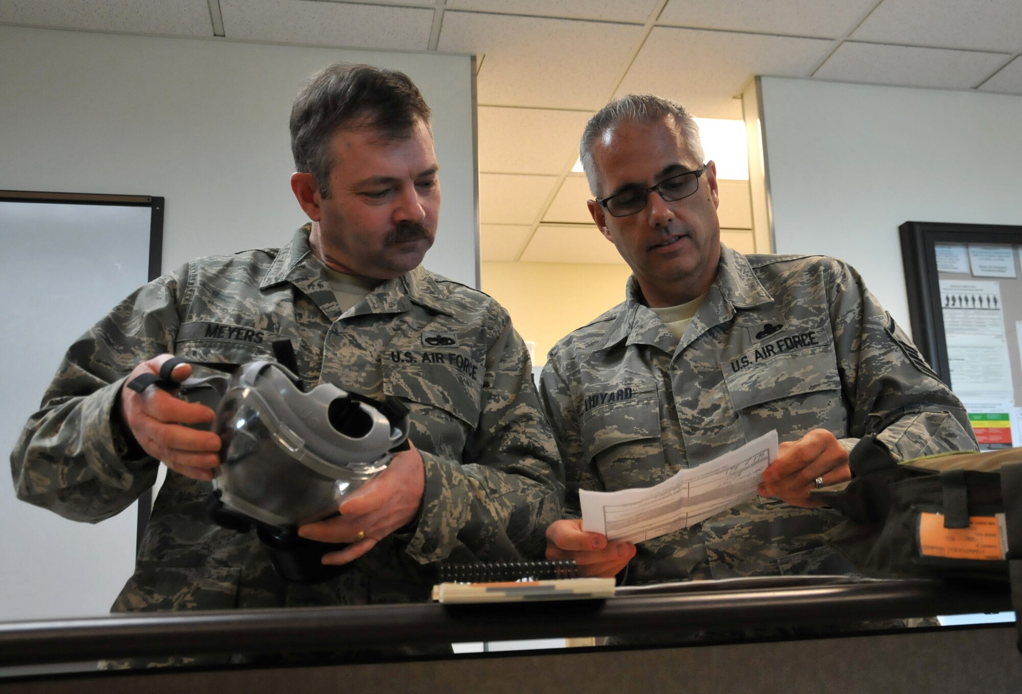MCCHORD FIELD, Wash.- Master Sgt. Brian Lidyard (right), 446th Aircraft Maintenance Squadron expeditor and former unit deployment manager, helps Master Sgt. Kerry Meyers, 446th AMXS, inspect his MCU-2P protective mask for maintenance, Feb. 9, 2011. Sergeant Lidyard just came back from a 120-day deployment in Iraq, which was his 10th deployment in his Reserve career. (U.S. Air Force photo/Master Sgt. Jake Chappelle)