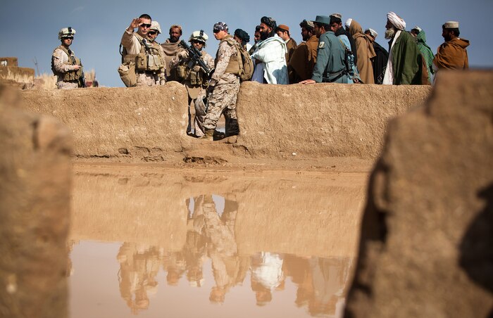 Capt. Alfred Butler, the commanding officer of Weapons Company, 2nd Battalion, 1st Marine Regiment, talks to elders of Belush, Garmsir District, Helmand province, Afghanistan, about flooding damage to the courtyard of a local mosque, Feb. 13. The flooding occurred the night before. Weapons Company's headquarters is Patrol Base Gorgak in Garmsir District.