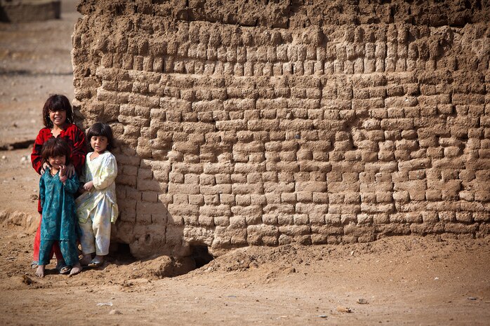 Local girls from Belush, Garmsir District, Helmand province, Afghanistan, watch Marines from Redemption II, Weapons Company, 2nd Battalion, 1st Marine Regiment, return from a patrol of their village Feb. 13. The Marines, who were surveying flooding damage from the night before, returned to Patrol Base Gorgak, their headquarters in Garmsir District.