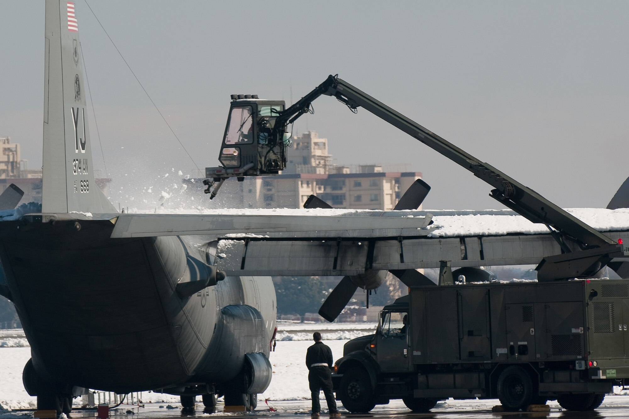 YOKOTA AIR BASE, Japan -- An Airman from the 374th Aircraft Maintenance Squadron de-ices a C-130 Hercules following a snow fall of five inches in just over seven hours Feb. 14-15. The accumulation paled in comparison to the record 15 inches of snow that fell at Yokota Feb. 15-16, 1968, breaking a mark that had stood since 1951. The record snowfall for Tokyo is 18.3 inches in 1883, according to historical records.  (U.S. Air Force photo/Osakabe Yasuo)