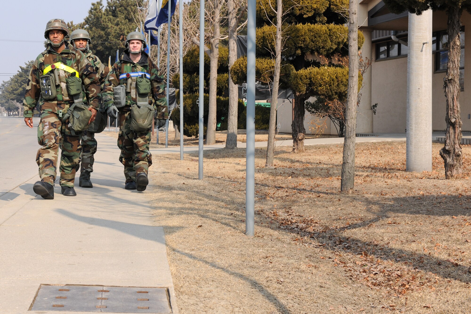 KUNSAN AIR BASE, Republic of Korea -- Wolf Pack members walk down the sidewalk on their way to their primary duty locations being sure to avoid stepping in the grass during exercise Beverly Midnight 11-1 here Feb. 15. Grassy areas are considered off-limits during exercises because of the possibility of contamination or other harmful situations. (U.S. Air Force photo/Tech. Sgt. Jonathan Pomeroy) 