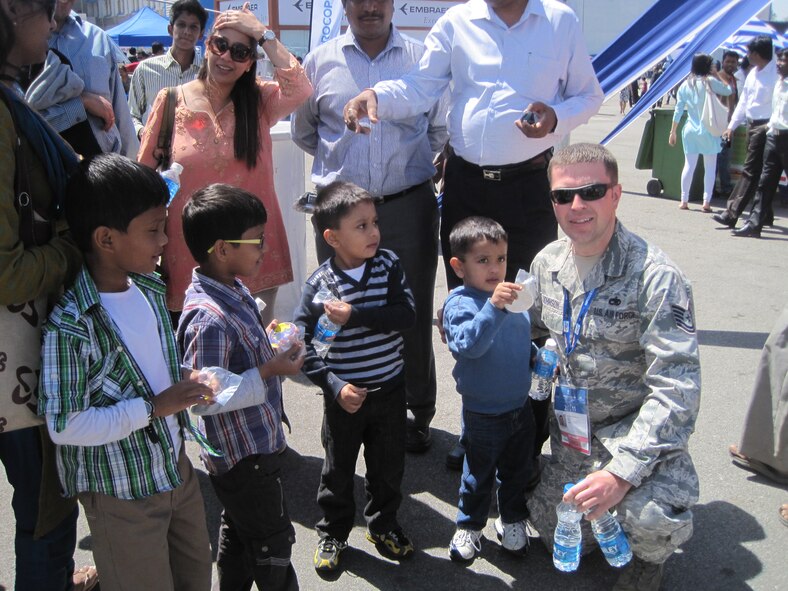 U.S. Air Force Tech. Sgt. Ryan Johnson hands out stickers to young air show enthusiasts at Aero India 2011 at Yelahanka Air Force Station, Bangalore, India, on Feb. 11 2011. Sergeant Johnson is a fueling technician with the 35th Aircraft Maintainence Squadron at Misawa Air Base, Japan, supporting the F-16 Fighting Falcom Pacific Demonstration Team. Aero India is a trade show held every two years. U.S. Pacific Command's participation in Aero India 11 directly supports engagement goals and objectives and furthers relations with other countries. The United States has supported Aero India since 2005. (U.S. Air Force photo/ Capt. Kirsten Udd) 