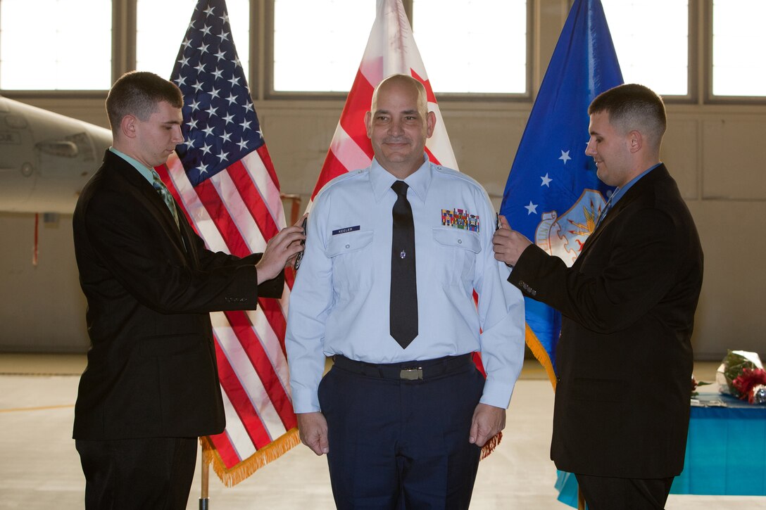 Chief Master Sgt. Louis R. Keeler gets pinned by his sons Jonathan and Zachary during his promotion ceremony. The 113th Maintenance Squadron held its first ever pining of three Chief Master Sergeants during a promotion ceremony on February 12, 2011 at Hanger 18, Andrews Air Force Base (U.S Air Force photo by Tech. Sgt. Gareth Buckland/Released)