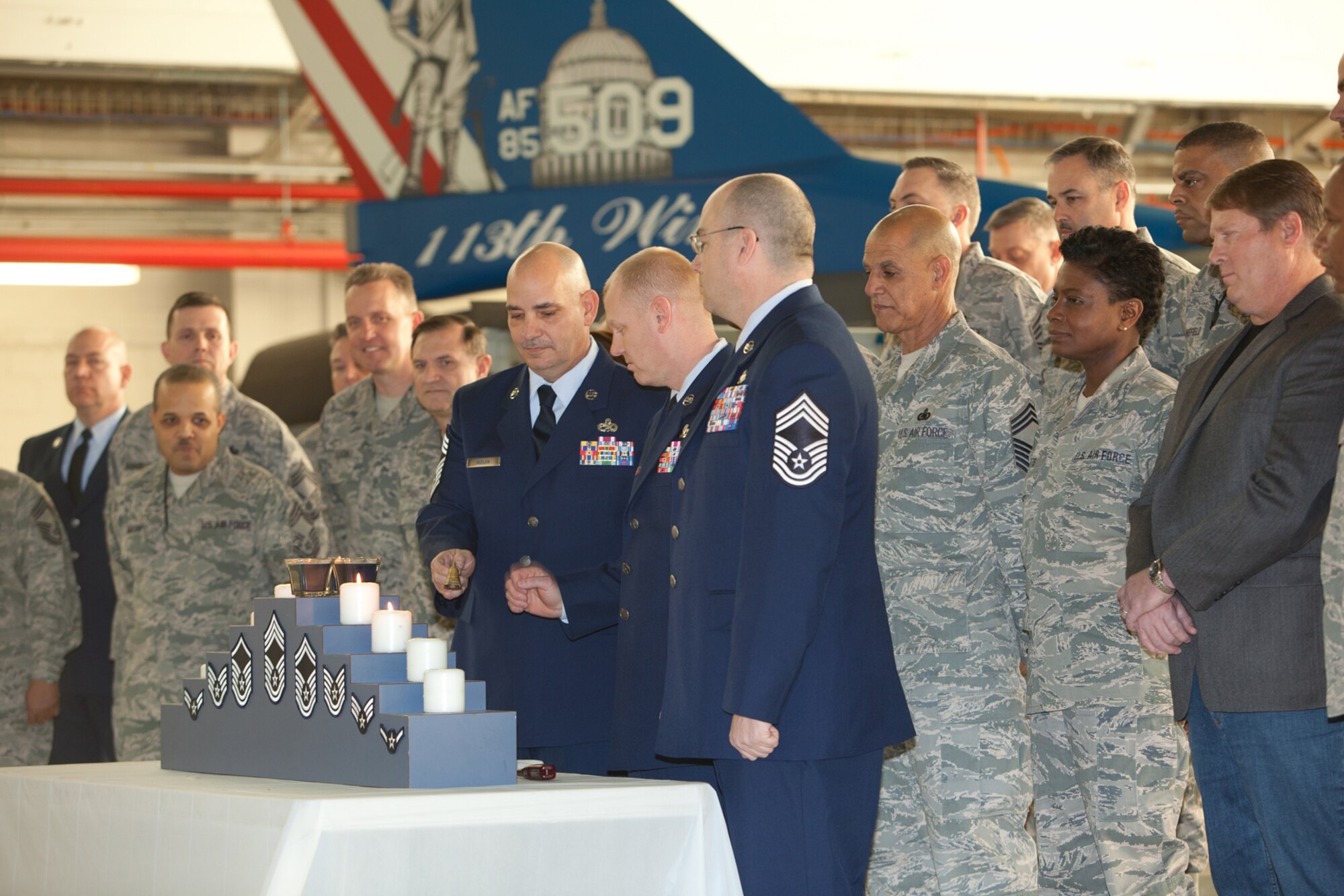 Chief Master Sgt. Louis R. Keeler, Chief Master Sgt. Kevin W. Kling, and Chief Master Sgt. James T. Mathews (left to right) extinguish the candles during their promotion ceremony. The 113th Maintenance Squadron held its first ever pining of three Chief Master Sergeants during a promotion ceremony on February 12, 2011 at Hanger 18, Andrews Air Force Base (U.S Air Force photo by Tech. Sgt. Gareth Buckland/Released)