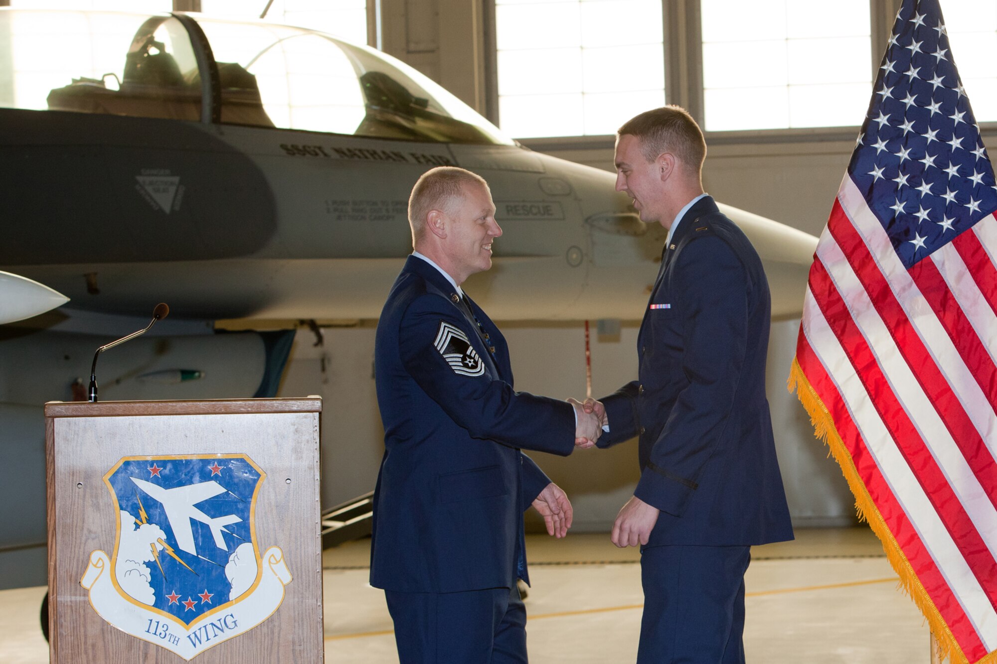 CMSgt Kevin Kling presents his son 2nd Lieutenant Adam Kling with a coin during his promotion ceremony. The 113th Maintenance Squadron held its first ever pining of three Chief Master Sergeants during a promotion ceremony on February 12, 2011 at Hanger 18, Andrews Air Force Base (U.S Air Force photo by Tech. Sgt. Gareth Buckland/Released)