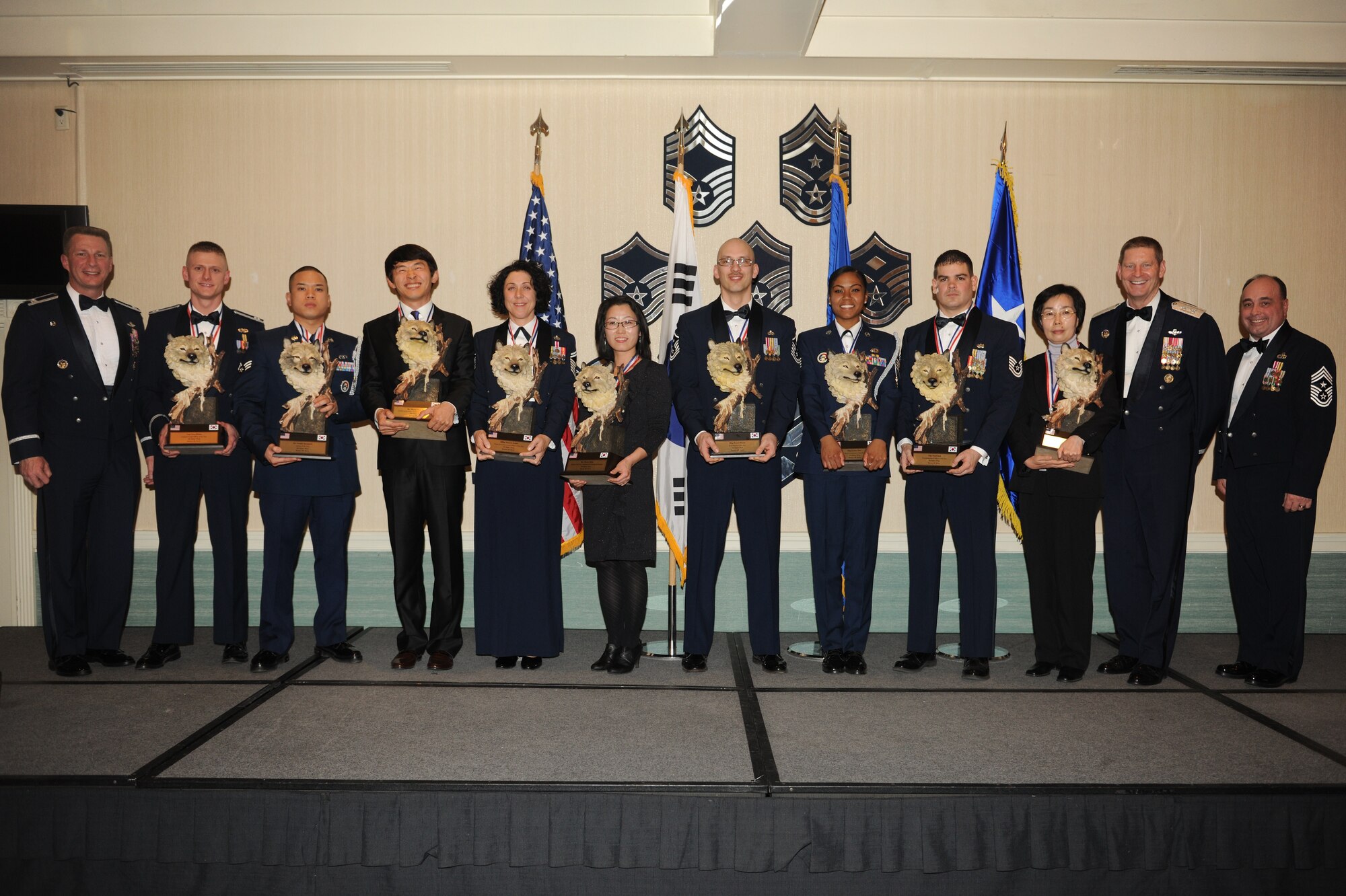 KUNSAN AIR BASE, Republic of Korea -- Col. John Dolan, 8th Fighter Wing commander (left), Chief Master Sgt. James Sanders, 8th Fighter Wing command chief (right), and Maj. Gen. Robin Rand, Special Assistant to the Vice Chief of Staff (second from right) honor the wing's annual award winners at a banquet Feb. 11. The award winners go on to compete against annual winners from 7th Air Force on Feb. 26. (U.S. Air Force photo/Senior Airman Ciara Wymbs) 