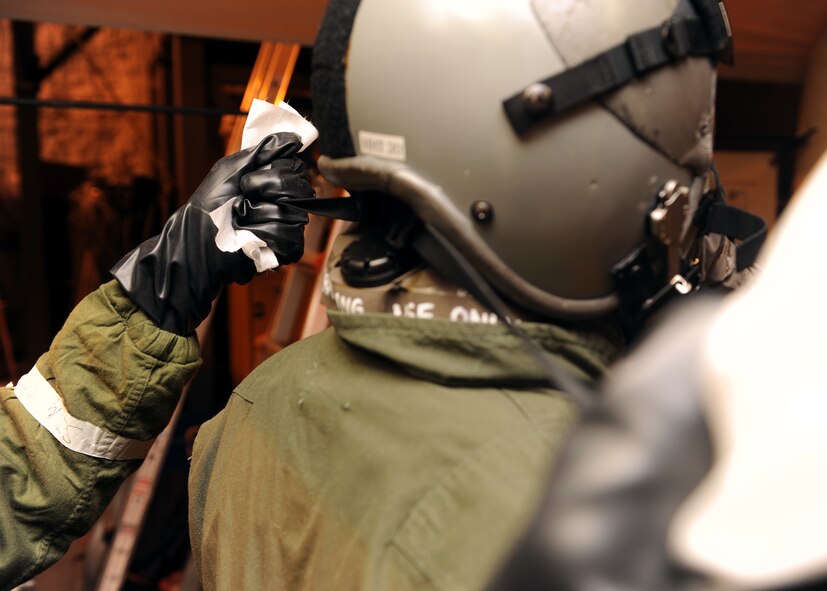 MINOT AIR FORCE BASE, N.D. -- Airman 1st Class Adolfo Villegas, 5th Operation Support Squadron aircrew flight equipment journeyman, tightens the straps of an aircrew member’s gas mask to ensure a proper seal is maintained during a decontamination exercise here Feb. 10. Training exercises like these provide Air Force Global Strike Command Airmen an avenue to keep their combat readiness skills sharp. (U.S. Air Force photo/Senior Airman Michael J. Veloz)