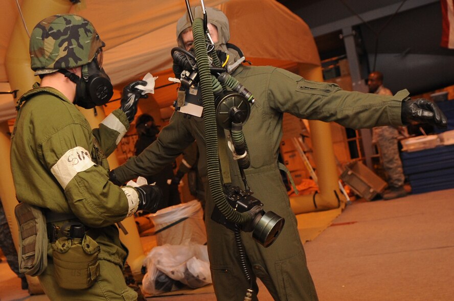MINOT AIR FORCE BASE, N.D. -- Airman 1st Class Kody Crider, 5th Operations Support Squadron aircrew flight equipment journeyman, conducts decontamination procedures on 1st Lt. Zachary Franklin, 23rd Bomb Squadron co-pilot, during a base exercise here Feb. 10. Training exercises like these provide Air Force Global Strike Command Airmen an avenue to keep their combat readiness skills sharp. (U. S. Air Force photo/Airman 1st Class Jose L. Hernandez) 