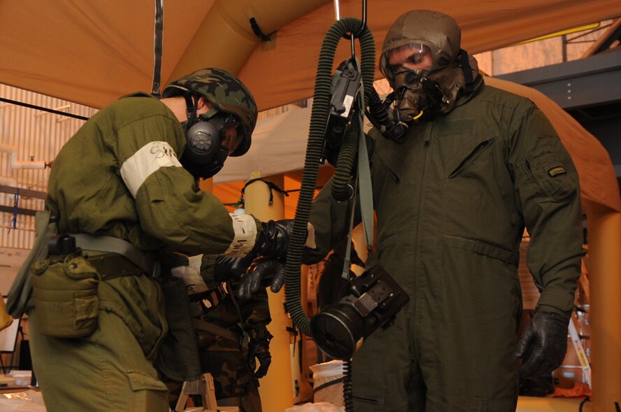 MINOT AIR FORCE BASE, N.D. -- Airman 1st Class Kody Crider, 5th Operations Support Squadron aircrew flight equipment journeyman, conducts decontamination procedures on Capt. Mark Burley, 23rd Bomb Squadron pilot, during a base exercise here Feb. 10. Training exercises like these provide Air Force Global Strike Command Airmen an avenue to keep their combat readiness skills sharp. (U. S. Air Force photo/Airman 1st Class Jose L. Hernandez) 
