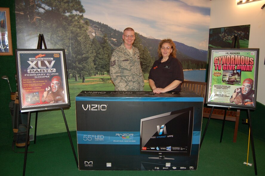 Gynormous TV Giveaway winner TSgt Daniel Hubbard, 5 MXS, received his prize from J.R. Rockers Assistant Manager Renee Price after winning the 55-inch Visio LED 120 Hz 1080p television valued at over $1,600.  The drawing was held at halftime during the Super Bowl Party Feb.6, 2011 as part of the club's annual Football Frenzy promotion at J.R. Rockers. (Courtesy photo)