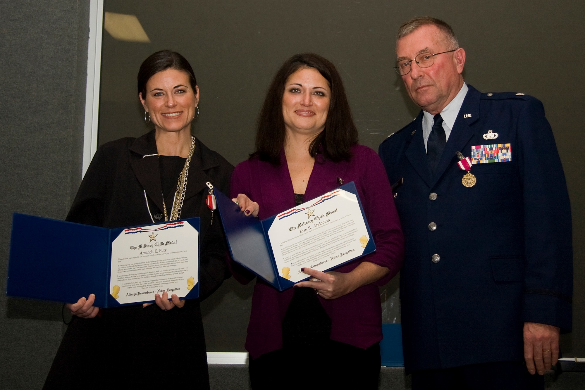 GRISSOM AIR RESERVE BASE, Ind. -- Amanda Putz, left, and Erin Anderson pose for a photo with their dad, Lt. Col. Phil Shott after he presented them with Military Child Medals during his retirement ceremony here recently. Colonel Shott retired as the 434th Mission Support Group deputy commander. (U.S. Air Force photo/Tech. Sgt. Mark R. W. Orders-Woempner)

