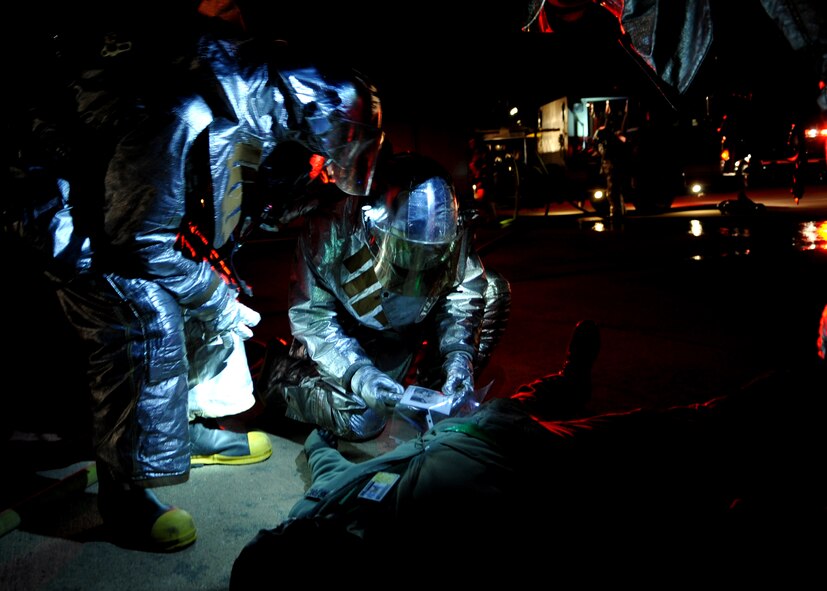 51st Fighter Wing firefighters treat a "casualty" after a simulated aircraft crash during Operational Readiness Exercise Beverly Midnight 11-01 at Osan Air Base, Republic of Korea Feb. 14.  The exercise allows Airmen to demonstrate their ability to complete the mission in simulated chemical environments while executing their primary duties, practicing self aid and buddy care, conduction post-attack reconnaissance and unexploded ordnance sweeps. (U.S. Air Force Photo/Senior Airman Evelyn Chavez)