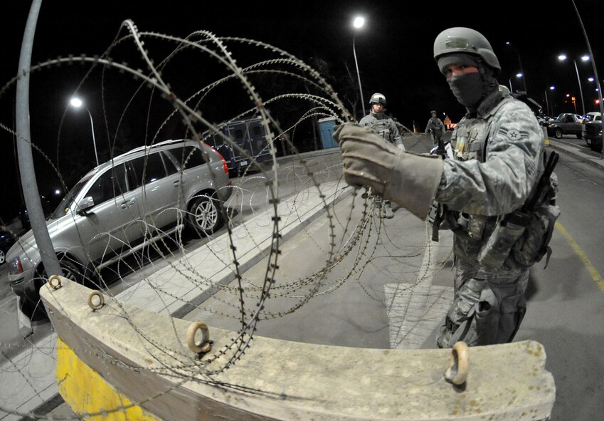 A 51st Fighter Wing Security Forces Airman secures a building during Operational Readiness Exercise Beverly Midnight 11-01 at Osan Air Base, Republic of Korea Feb. 14.  The exercise allows Airmen to demonstrate their ability to complete the mission in simulated chemical environments while executing their primary duties, practicing self aid and buddy care, conduction post-attack reconnaissance and unexploded ordnance sweeps. (U.S. Air Force Photo/Senior Airman Evelyn Chavez)