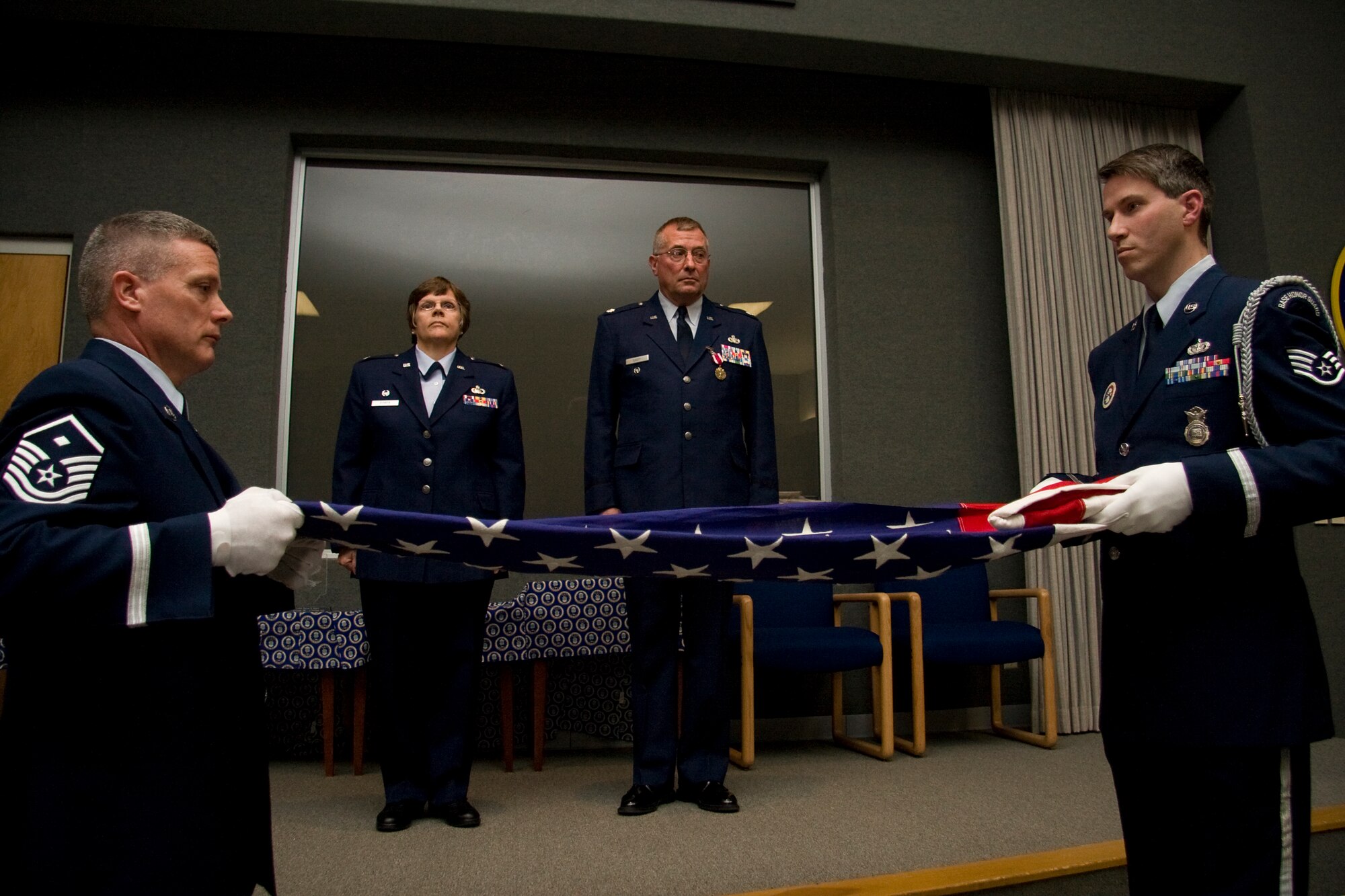 GRISSOM AIR RESERVE BASE, Ind. -- Master Sergeant Bill Hurley, left, and Staff Sgt. Ben Durr fold an American flag as Col. Betty Bowen and Lt. Col. Phil Shott stand at attention during the presentation. The flag was presented by the two Grissom Honor Guard members to Colonel Shott during his retirement ceremony here recently. Colonel Bowen is the 434th Mission Support Group commander and Colonel Shott was the 434th MSG deputy commander. (U.S. Air Force photo/Tech. Sgt. Mark R. W. Orders-Woempner)
