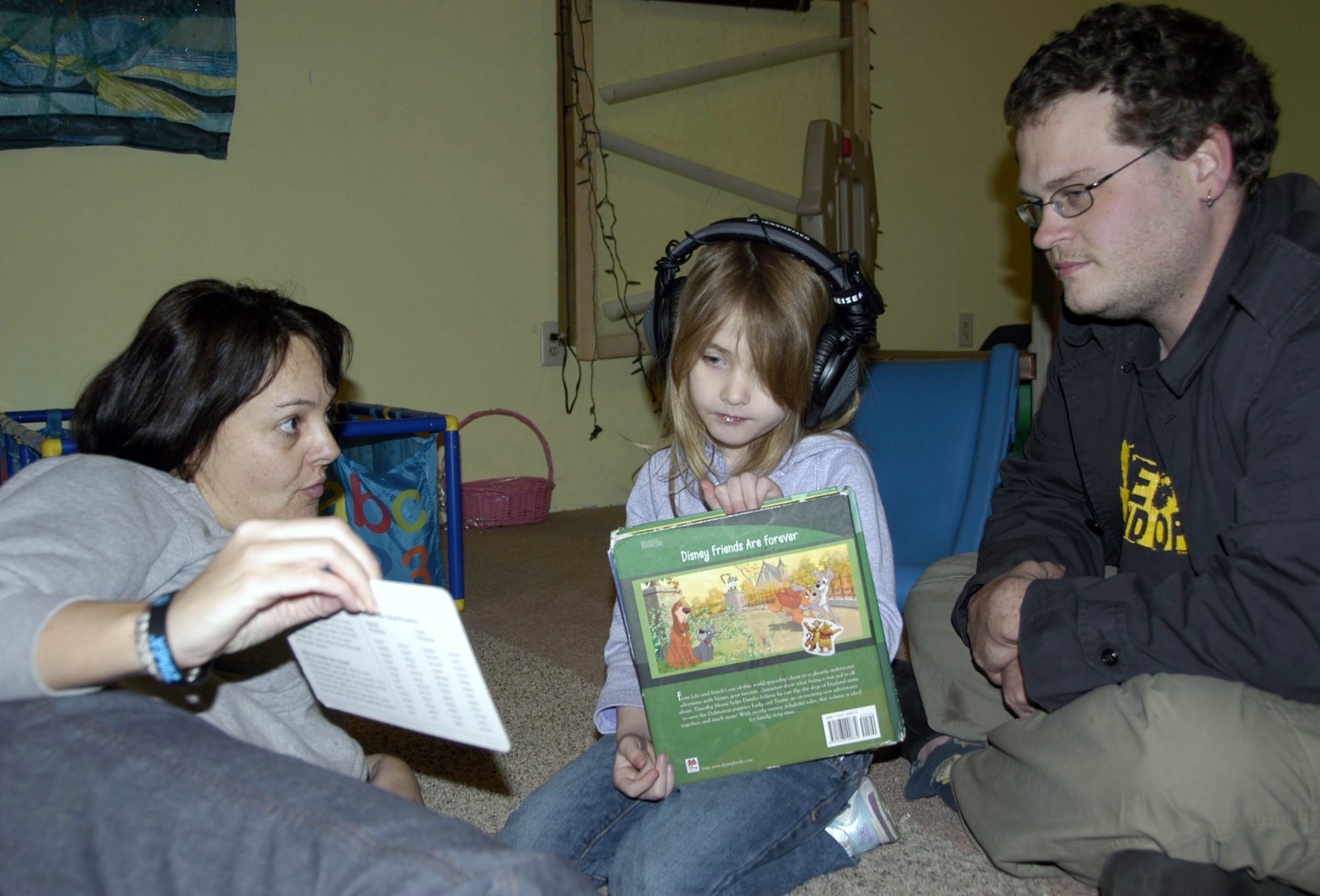 Helen Ezell, founder and director of the Autism Education Center in Lynn Haven, Fla., works with 5-year-old Erika Mickle and her father Erik Mickle during a therapy session at the center. Because of her efforts with the AEC and within the community, Mrs. Ezell was named Lynn Haven’s Citizen of the Year. (U.S. Air Force photo/Angela Pope)