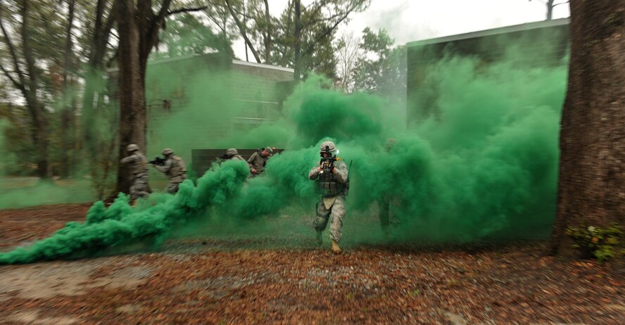 MOODY AIR FORCE BASE, Ga.-- Airmen from the 822nd Base Defense Squadron run through green smoke after clearing buildings during a training at a military operations in urban terrain village training facility during a base visit from Brig. Gen. Jimmy McMillian, Headquarters Air Force director of security forces Feb. 10. (U.S. Air Force photo/Airman 1st Class Joshua Green)(RELEASED)
