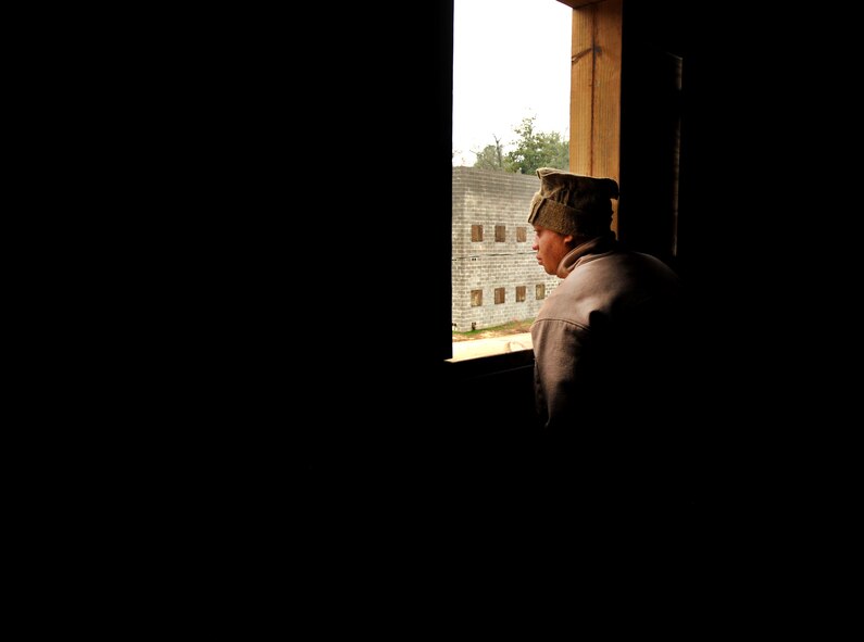 MOODY AIR FORCE BASE, Ga.-- Senior Airman Kevin Richardson, 823rd Base Defense Squadron fire team member, looks out of a window during a training scenario at a military operations in urban terrain village training facility Feb. 10. The training demonstration was displayed for Brig. Gen. Jimmy McMillian, Headquarters Air Force director of security forces, during a base visit. (U.S. Air Force photo/Airman 1st Class Joshua Green)(RELEASED)
