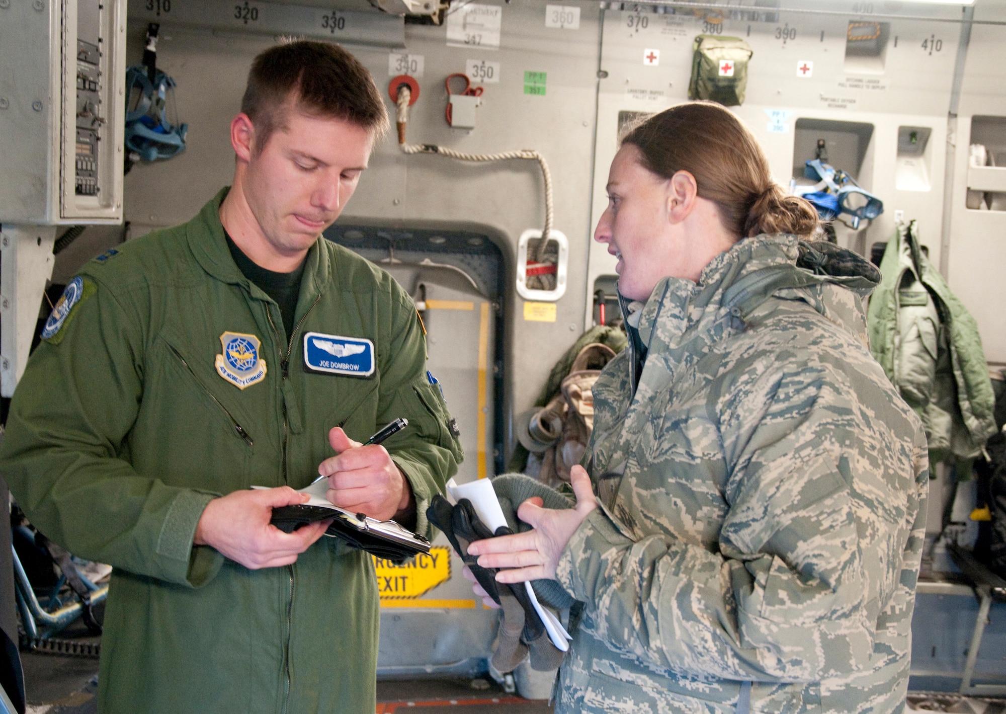FORT BRAGG N.C. -- Capt. Joe Dombrow, 17th Airlift Squadron pilot, writes down notes as Capt. Dawn Hildebrand, air mobility liaison officer, briefs him about the drop zone location during a joint airdrop Jan. 22 at Camp Mackall, N.C. (U.S. Army Photo by Michelle Butzgy/Paraglide)
