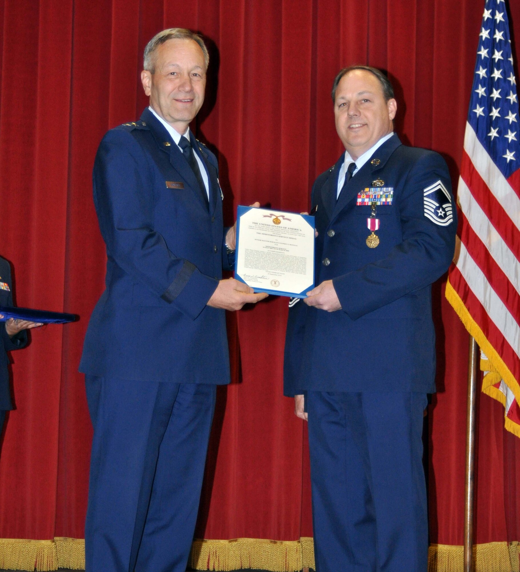 Maj. Gen. Eric W. Crabtree, commander of Fourth Air Force, presents the Meritorius Service Medal to Senior Master Sgt. Stephen J. Rouille during a commander's call ceremony at March Air Reserve Base, Calif., February 13, 2011.