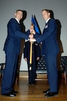 LAUGHLIN AIR FORCE BASE, Texas -- Colonel Craig Wills, 47th Operations Group commander, hands the 47th Operations Support Squadron guide-on to Lt. Col. John Binder, the new  47th OSS commander, during the 47th OSS change of command ceremony Feb. 11. Lieutenant Col. Binder assumed command from Lt. Col. Michael Brockey, the new 47th Operations Group deputy commander. (U.S. Air Force photo by Jose Mendoza)