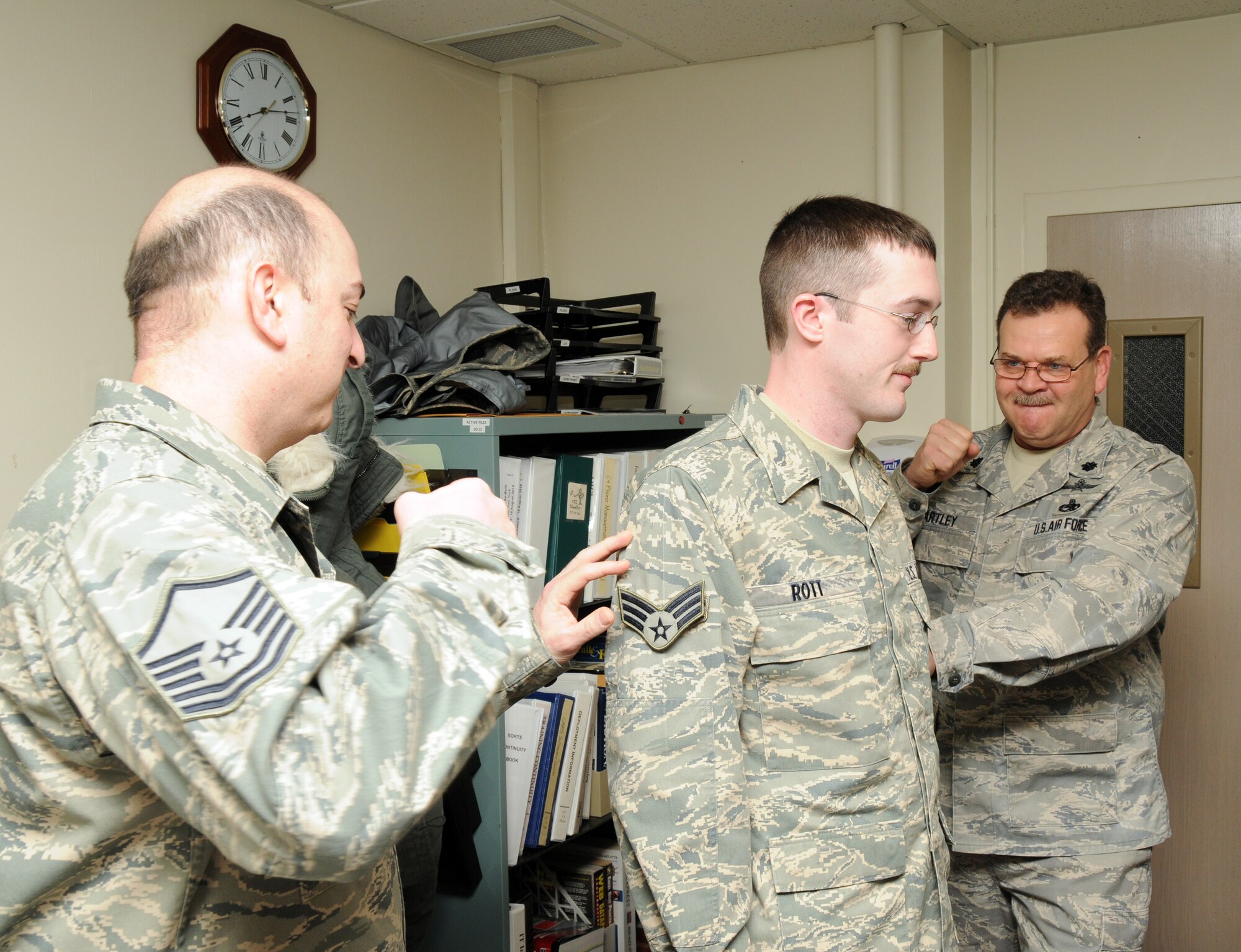 Airman 1st Class Philip Rott from the 107th AW Communications Flight is promoted to senior airman by Master Sgt. Joel Micoli (on left) and Lt. Col. Doug Hartley (on right). (U.S. Air Force photo/Tech. Sgt. Justin Huett)