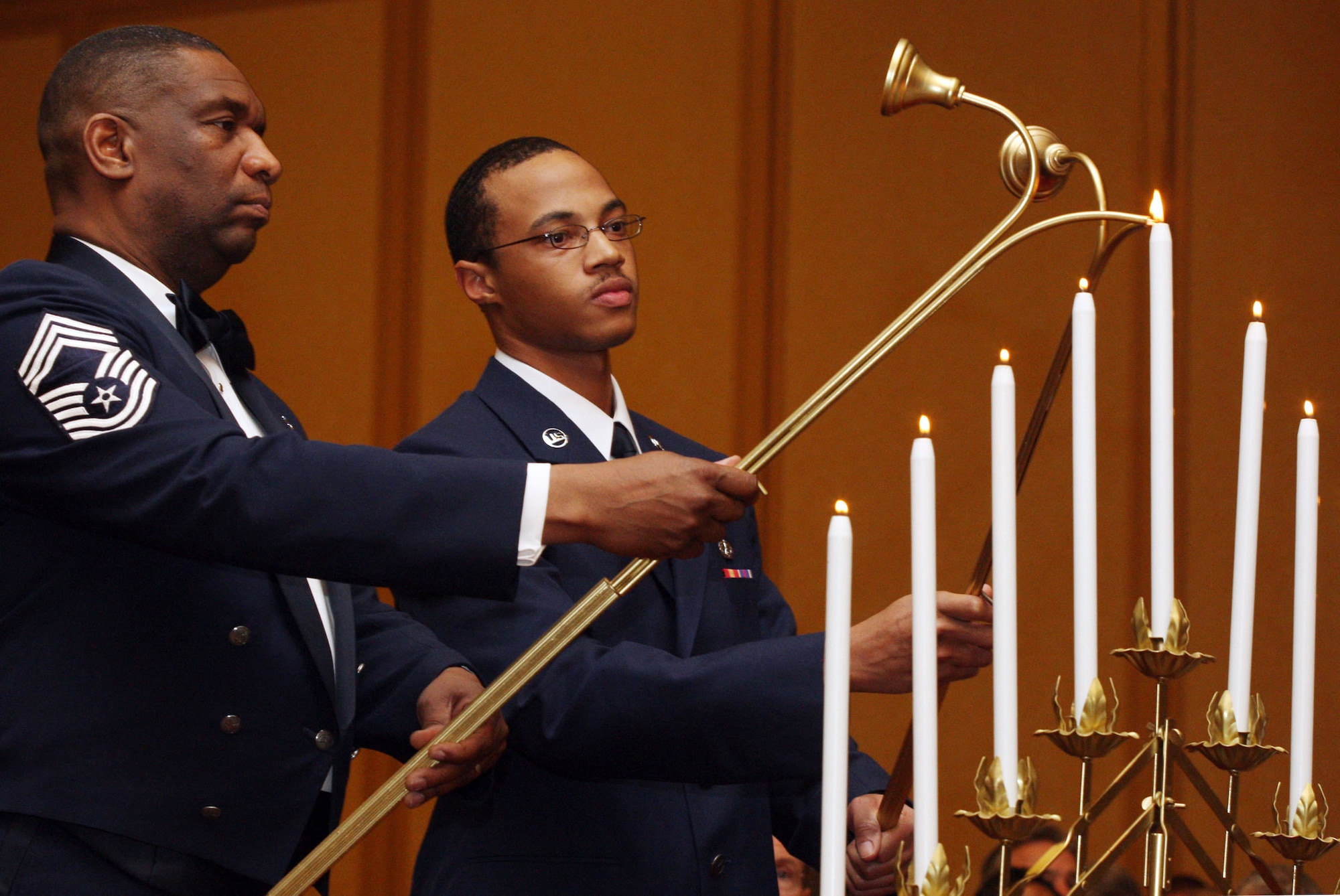 Chief Master Sgt. Gregory Gamble, Dobbins' Senior Chief, and Airman Derick Davis, the most junior enlisted member light the top candle representing achievement of the highest enlisted grade and signifying lighting the way for others to follow. (U.S. Air Force Photo/Don Peek)