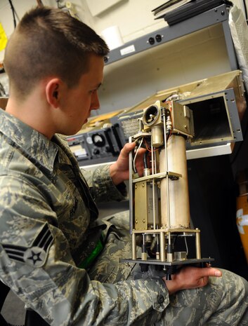 Senior Airman Amos Hommel visually inspects a tuning cavity or "squirrel cage" on a GRT-22 radio amplifier as part of a periodic maintenance inspection at the transmissions systems office Feb. 11, 2011 on Joint Base Charleston, S.C. Checking for obstructions, corrosion and anything out of the ordinary is crucial to maintaining the units functionality over a long period of time. Airman Hommel is a Radio Frequency Transmissions Systems Technician with the 628th Communications Squadron. (U.S. Air Force photo/Senior Airman Timothy Taylor)