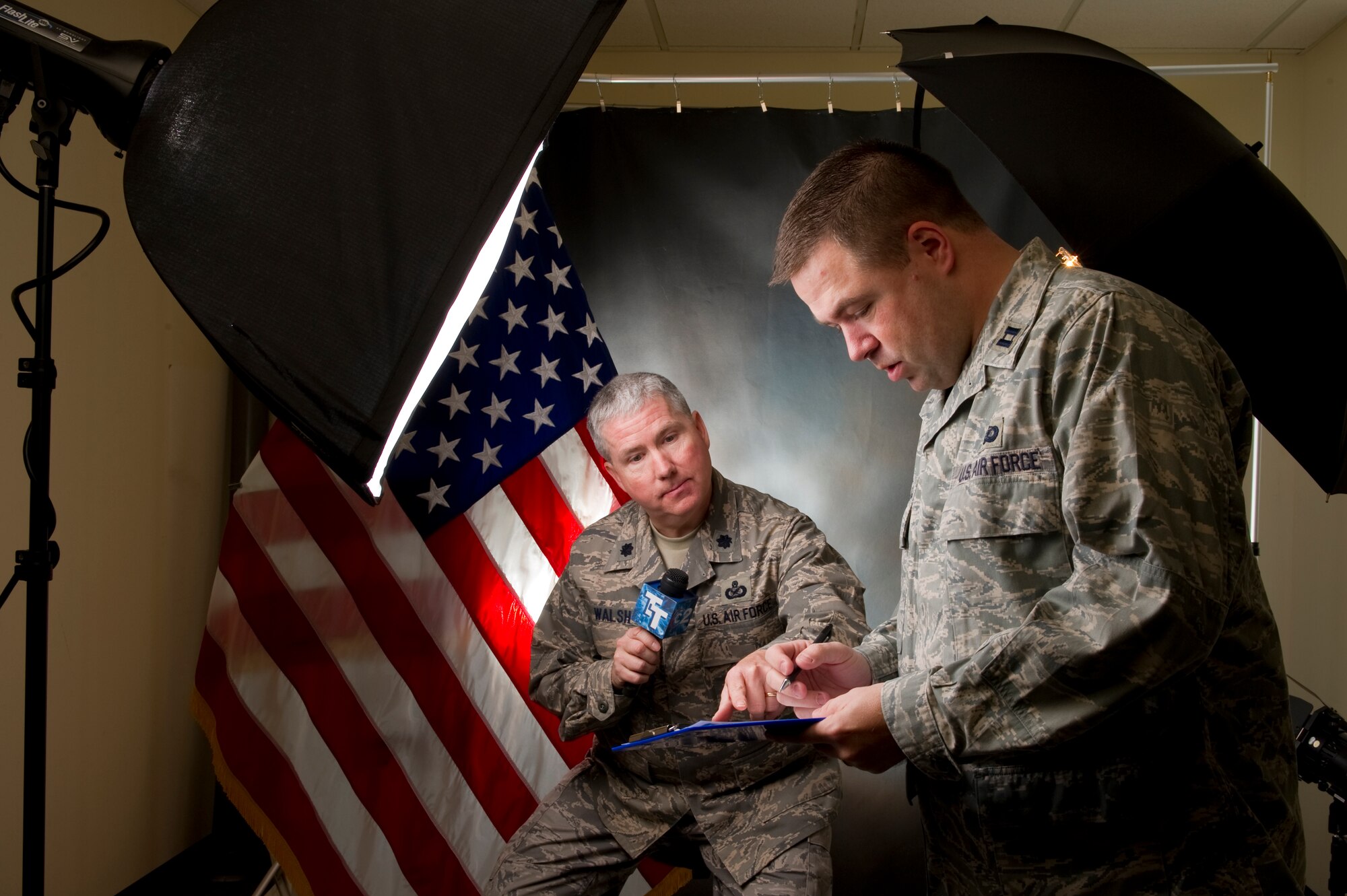 To depict public affairs, Stacy Pearsall depicted Lt. Col. Bill Walsh (left) and Capt. Wayne Capps going over a script in the public affairs studio.  (Courtesy Photo by Stacy Pearsall)