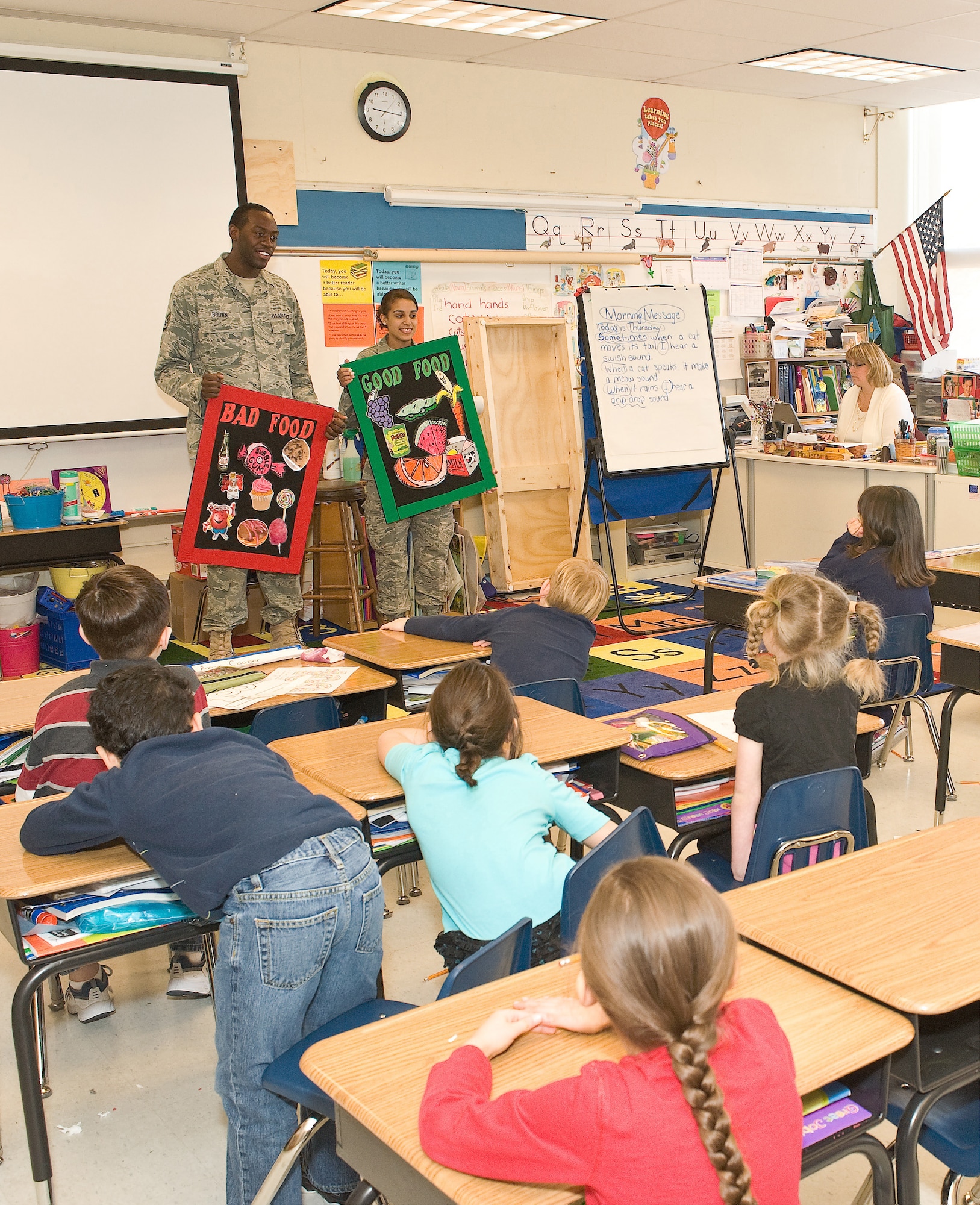 Staff Sgt. James Brown and Airman 1st Class Dejon Kidd, both assigned to the 436th Dental Squadron, show charts of good and bad foods for teeth as part of Children Dental Health Month, Feb. 10, 2011, at Dover AFB, Del. The majority of good foods are low in sugar and high in fiber, and the majority of the bad are high in sugar and empty calories. (U.S. Air Force photo/Roland Balik)
