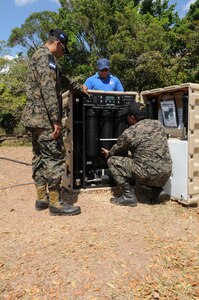 SOTO CANO AIR BASE, Honduras -- Joint Task Force-Bravo, the Honduran military and the Comisión Permanente de Contingencias, trained and exercised on equipment together here Feb. 2 through 10, on equipment that can enable them to provide aid following disasters. Here Honduran military representatives National Defense University assistance, set up the water desalination machine. This machine is a portion of the Prepositioned Exercise Assistance Kit which filters murky or salt water into drinkable water. JTF-Bravo is committed to full partnerships with Central American governments in training and missions to support security, stability and prosperity throughout the region. (U.S. Air Force photo/Staff Sgt. Kimberly Rae Moore)
