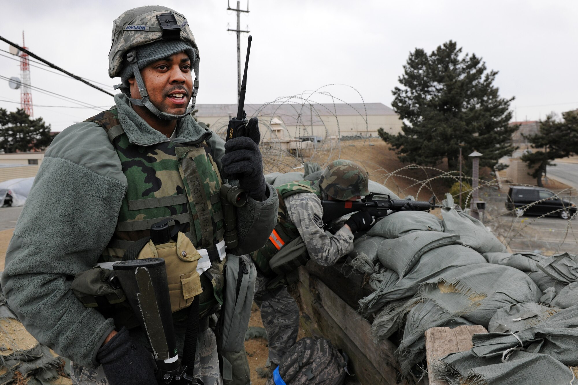 KUNSAN AIR BASE, Republic of Korea -- Tech. Sgt. Parrish Johnson, 8th Communications Squadron member, relays status information back to his command section as Staff Sgt. Derek E. Langford, also of the 8th CS, mans a defensive position and scans for opposing forces during exercise Beverly Midnight 11-1 here Feb. 14.  Staying vigilent is one of the main keys to mission success during peace time and times of war.  (U.S. Air Force photo/Tech. Sgt. Jonathan Pomeroy) 