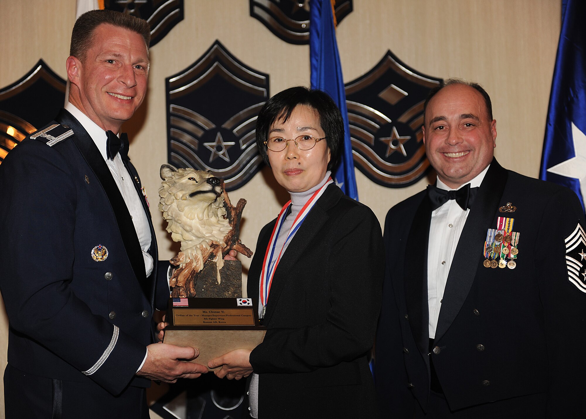 KUNSAN AIR BASE, Republic of Korea -- Col. John Dolan, 8th Fighter Wing commander, and Chief Master Sgt. James Sanders, 8th Fighter Wing command chief, present Yi Chun-Ae, 8th Comptroller Squadron, with the 8th FW’s Category 3 Outstanding Civilian of the Year award Feb. 11. Ms. Yi will go on to compete against annual winners from 7th Air Force on Feb. 26. (U.S. Air Force photo/Senior Airman Ciara Wymbs)  