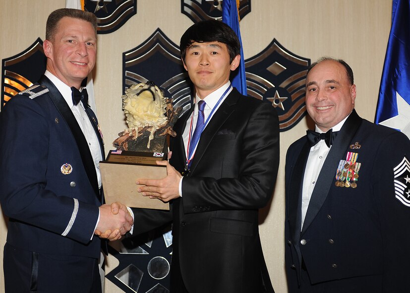 KUNSAN AIR BASE, Republic of Korea -- Col. John Dolan, 8th Fighter Wing commander, and Chief Master Sgt. James Sanders, 8th Fighter Wing command chief, present Mr. Kim Hyong-Chun, 8th Force Support Squadron, with the 8th FW’s Category 1 Outstanding Civilian of the Year award. Mr. Kim will go on to compete against annual winners from 7th Air Force on Feb. 26. (U.S. Air Force photo/Senior Airman Ciara Wymbs)  