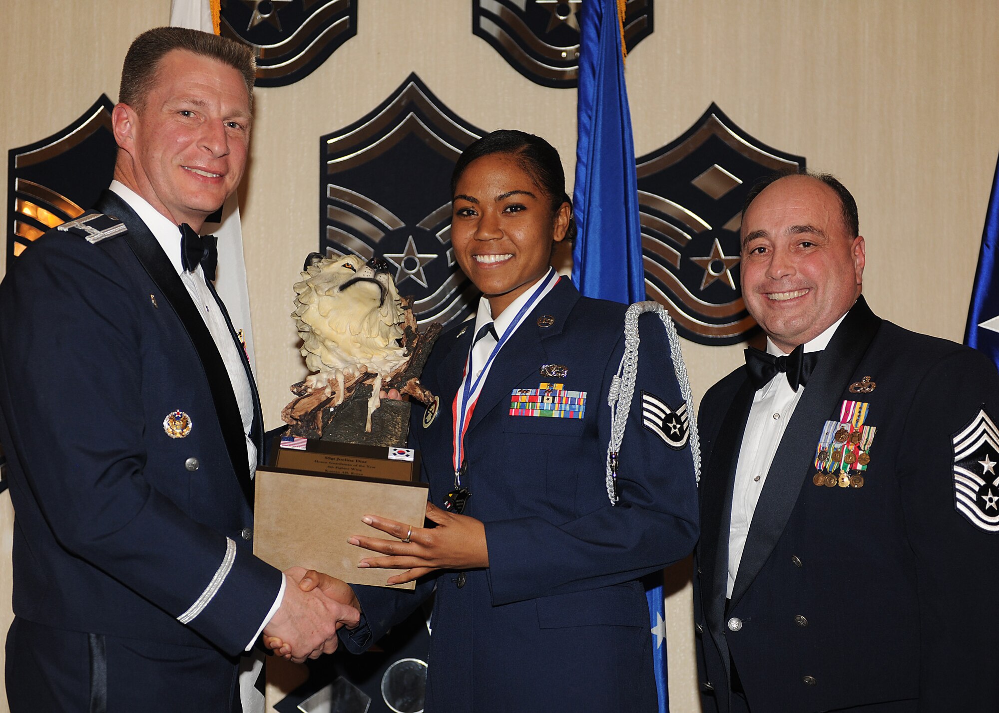 KUNSAN AIR BASE, Republic of Korea -- Col. John Dolan, 8th Fighter Wing commander, and Chief Master Sgt. James Sanders, 8th Fighter Wing command chief, present Staff Sgt. Joelina Diaz, 8th Force Support Squadron, with the 8th FW’s Honor Guard Member of the Year award. Sergeant Diaz will go on to compete against annual winners from 7th Air Force on Feb. 26. (U.S. Air Force photo/Senior Airman Ciara Wymbs)  