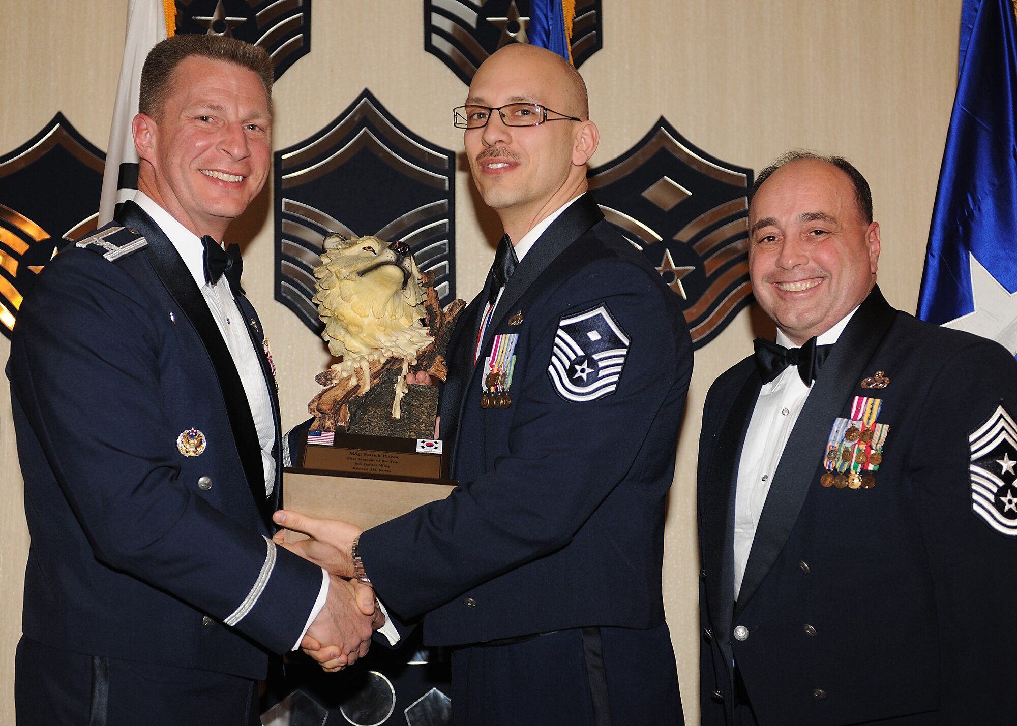 KUNSAN AIR BASE, Republic of Korea -- Col. John Dolan, 8th Fighter Wing commander, and Chief Master Sgt. James Sanders, 8th Fighter Wing command chief, present Master Sgt. Patrick Piazza, 8th Logistics Readiness Squadron, with the 8th FW’s First Sergeant of the Year award. Sergeant Piazza will go on to compete against annual winners from 7th Air Force on Feb. 26. (U.S. Air Force photo/Senior Airman Ciara Wymbs)  