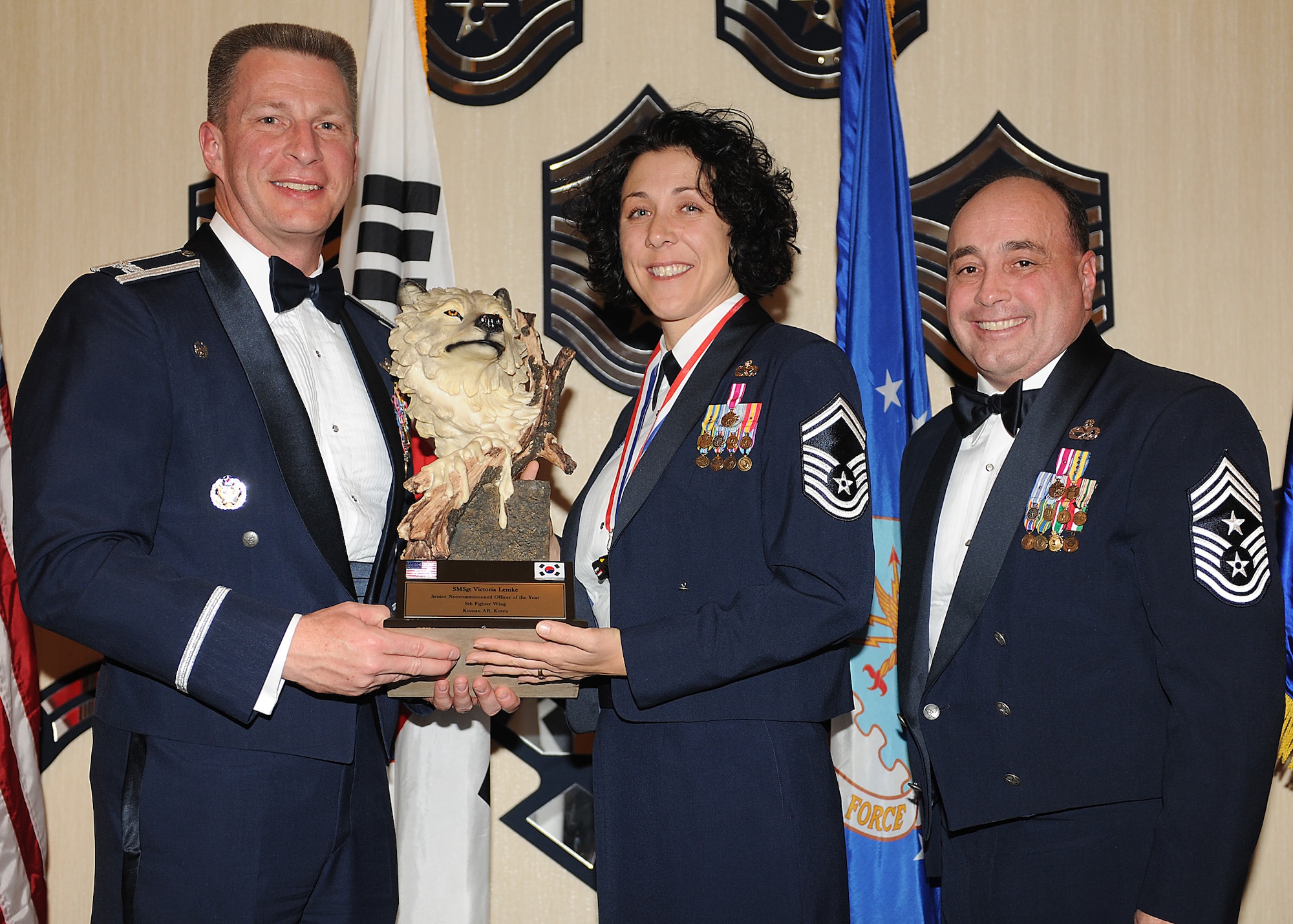 KUNSAN AIR BASE, Republic of Korea -- Col. John Dolan, 8th Fighter Wing commander, and Chief Master Sgt. James Sanders, 8th Fighter Wing command chief, present Senior Master Sgt. Victoria Lemke, 8th Maintenance Squadron, with the 8th FW’s Senior NCO of the Year award. Sergeant Lemke will go on to compete against annual winners from 7th Air Force on Feb. 26. (U.S. Air Force photo/Senior Airman Ciara Wymbs)  