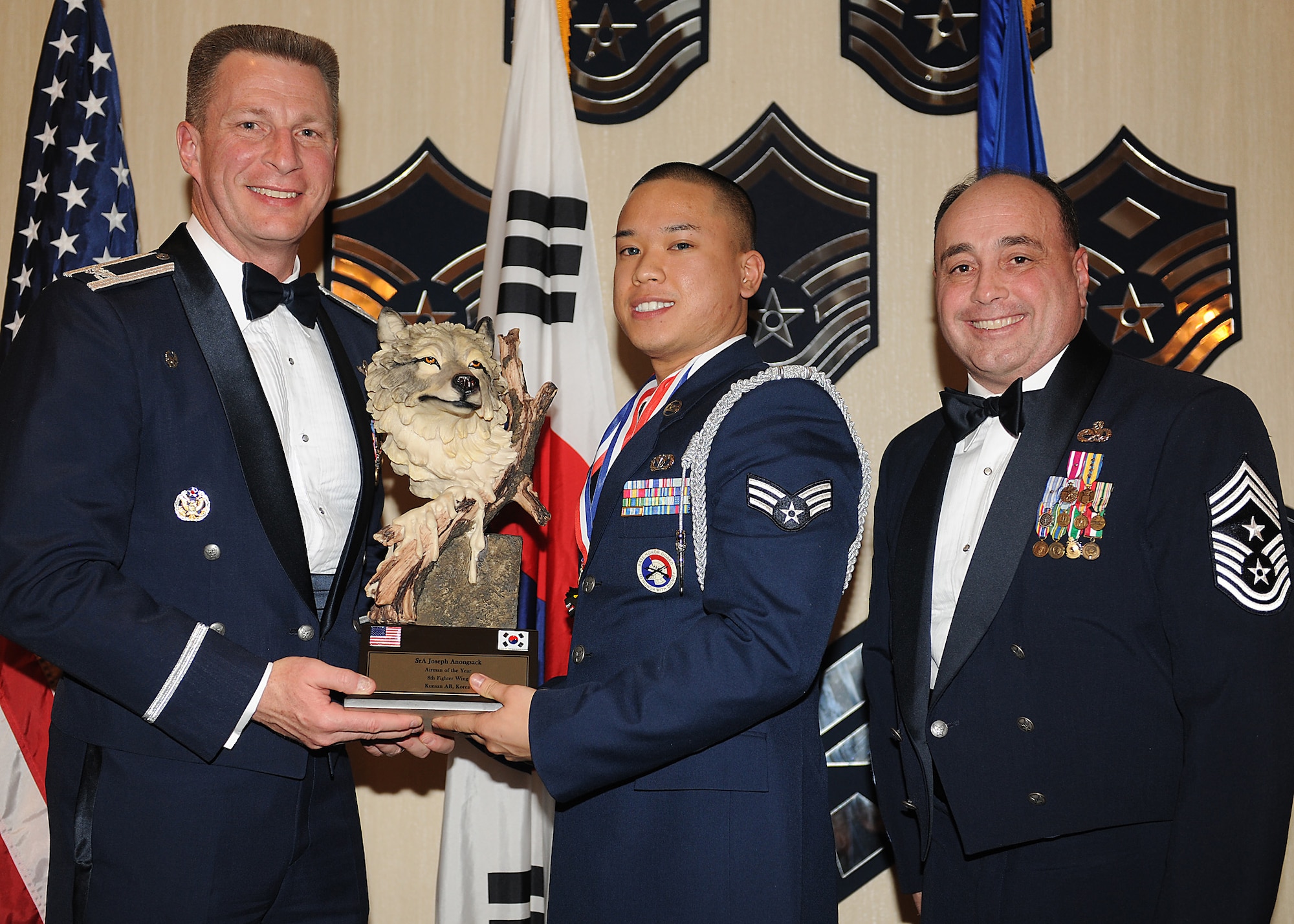KUNSAN AIR BASE, Republic of Korea -- Col. John Dolan, 8th Fighter Wing commander, and Chief Master Sgt. James Sanders, 8th Fighter Wing command chief, present Senior Airman Joseph Anongsack, 8th Civil Engineer Squadron, with the 8th FW’s Airman of the Year award. Airman Anongsack will go on to compete against annual winners from 7th Air Force on Feb. 26. (U.S. Air Force photo/Senior Airman Ciara Wymbs)  