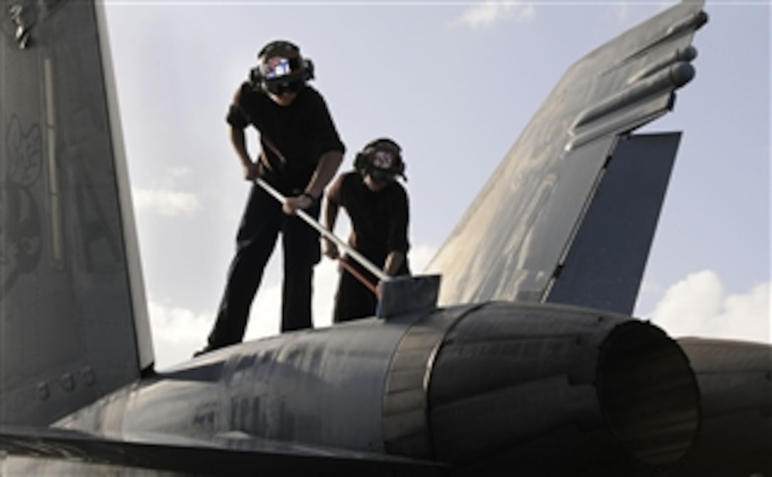 Airman Recruit Teddy Frisby (left) and Airman Apprentice Kevin Dwyer, both assigned to Strike Fighter Squadron 113, wash an F/A-18C Hornet on the flight deck of the aircraft carrier USS Carl Vinson (CVN 70) in the Arabian Sea on Feb. 11, 2011.  The Carl Vinson Carrier Strike Group is deployed supporting maritime security operations and theater security cooperation efforts in the U.S. 5th Fleet area of responsibility.  