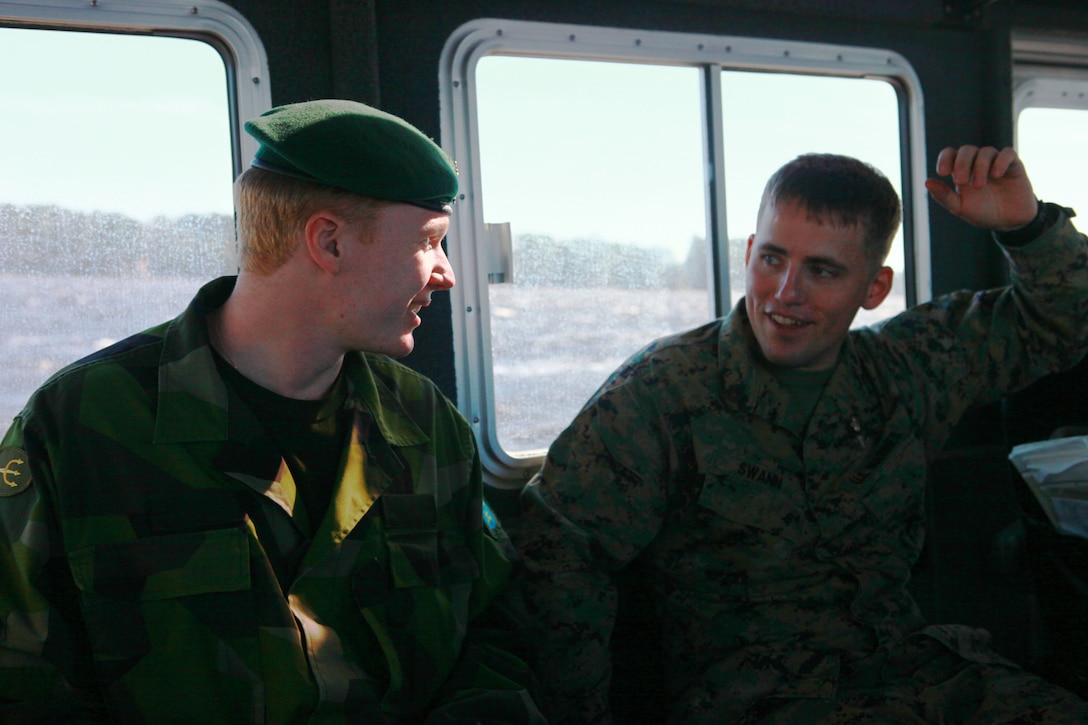 Swedish Reconnaissance Marine Pfc. Eric Ramstrom (left) speaks with Staff Sgt. Joshua Swann (right), a training non-commissioned officer with Force Reconnaissance Company, II Marine Expeditionary Force, while taking a boat ride around Marine Corps Base Camp Lejeune, N.C., Feb 14. Ramstrom and Rantanen toured several Marine Corps instillations on the east coast including Marine Corps Recruit Depot Paris Island, S.C. where they observed recruit training.