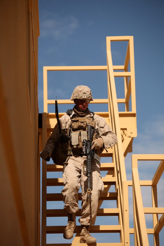 A Marine with  1st Battalion, 5th Marine Regiment, descends a flight of stairs after conducting a search of a roof top in the Combat Center’s new combined arms, live-fire, Military Operations on Urban Terrain training range, in search of improvised explosive devices  as part of Enhanced Mojave Viper, Feb. 15, 2011.