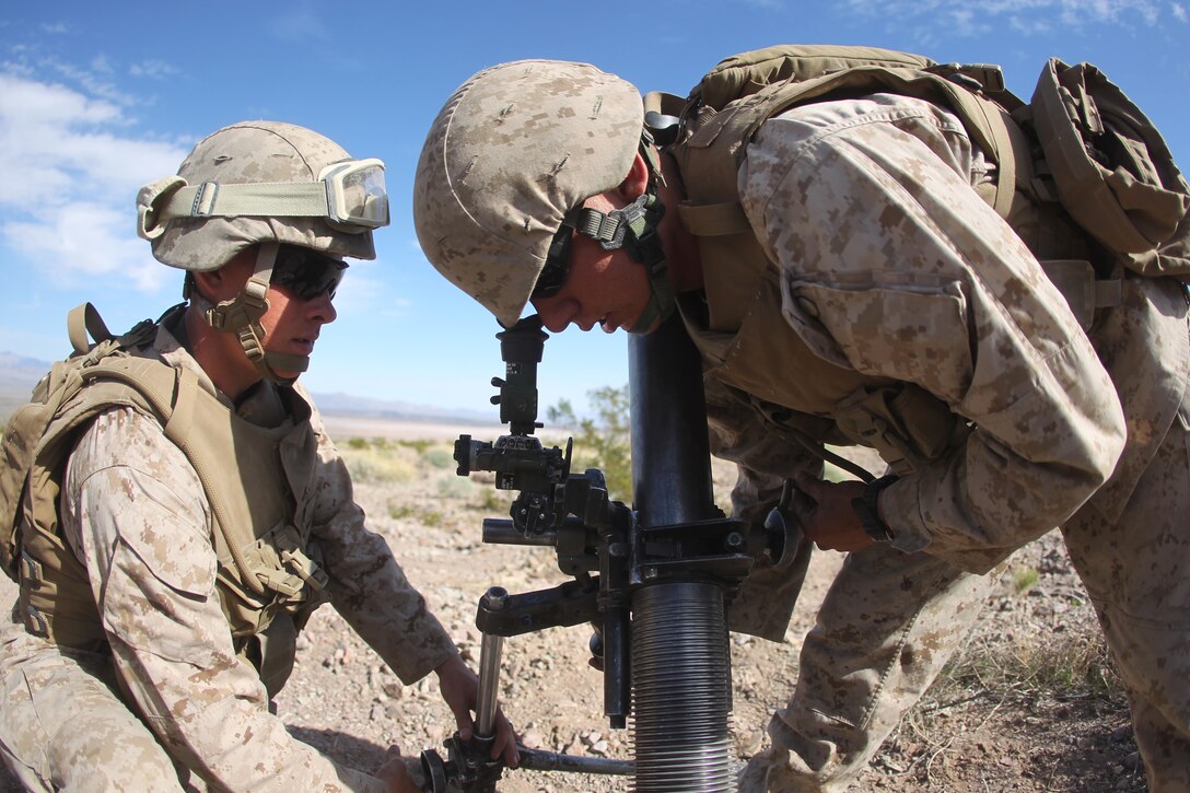 Lance Cpl. Jeff Riley [left], and Pfc. Samuel Robertson, both mortarmen with Weapons Company, 2nd Battalion, 7th Marine Regiment, line up their mortar system Feb. 15, 2011 during the battalion’s training at the Combat Center’s Lead Mountain Training Area.
