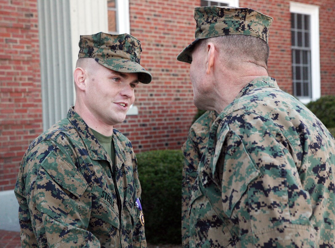 Lance Cpl. Brian K. Steele, a combat engineer with 2nd Marine Logistics Group, speaks with Col. Kenneth Enzor, the chief of staff for the 2nd MLG, during a purple heart ceremony in front of the 2nd MLG Headquarters building aboard Camp Lejeune, N.C., Feb. 14, 2011. Steele was a vehicle commander during a convoy near Forward Operating Base Hansen when his vehicle struck an improvised explosive device. (U.S. Marine Corps photo by Pfc. Franklin E. Mercado)