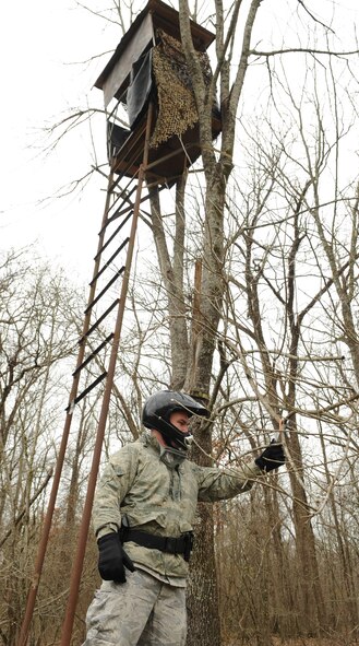 Senior Airman Chace Northcutt, 2nd Security Forces Squadron, checks the inspection tag on a deer stand on the East Side of base during his routine checks as a game warden on Barksdale Air Force Base, La., Feb. 15. Game wardens look for the correct inspection number, year, name and phone number on the tag for proper registration. (U.S. Air Force photo/ Senior Airman Alexandra M. Boutte) (RELEASED)