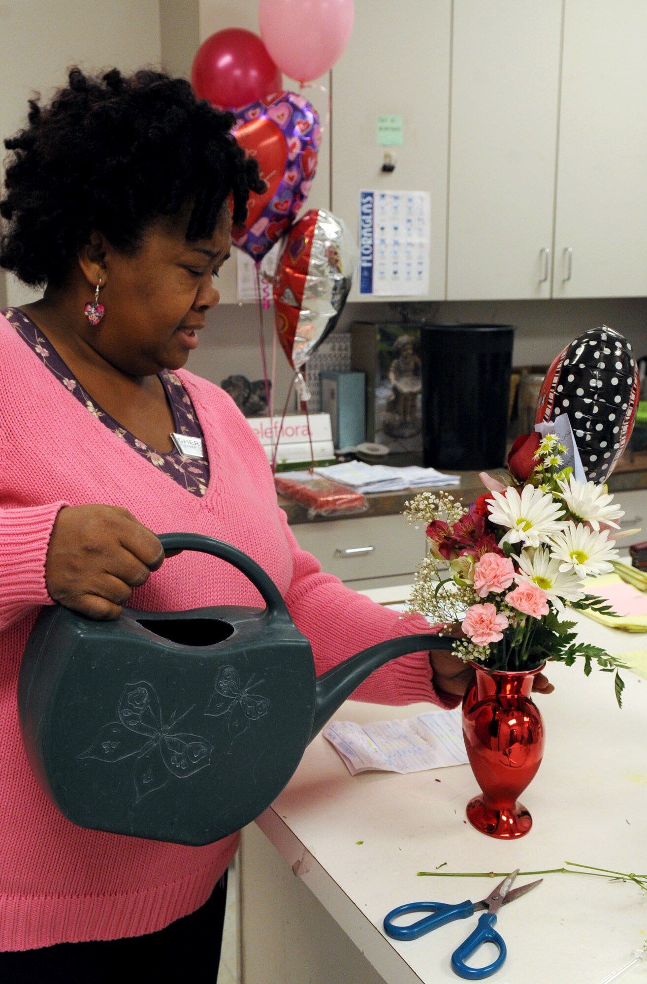 BARKSDALE AIR FORCE BASE, La. -- Mrs. Cheryl Williams, Barksdale's Pedals and Blooms Flower florist designer, pours water into a heart-shaped vase after she finishes a floral arrangement Feb. 15. Although the floral shop prepared more than 300 arrangements for Valentine's Day the day after is still a busy day for the shop. The floral shop designs arrangements for all types of occasions. (U.S. Air Force Photo/Senior Airman La'Shanette V. Garrett) (RELEASED)