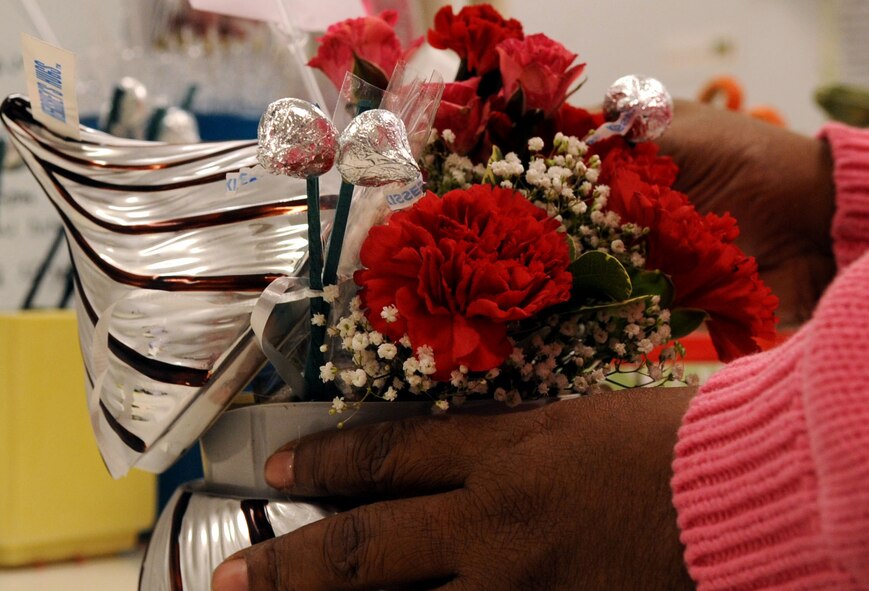 BARKSDALE AIR FORCE BASE, La. -- Mrs. Cheryl Williams, Barksdale's Pedals and Blooms Flower florist designer, prepares a floral arrangement in a Hershey's Kiss vase Feb. 15. Although the Floral shop prepared more than 300 arrangements for Valentine's Day the orders are still continuing to come in.  Valentine's Day is one of the busiest days for the shop. (U.S. Air Force Photo/Senior Airman La'Shanette V. Garrett) (RELEASED) 