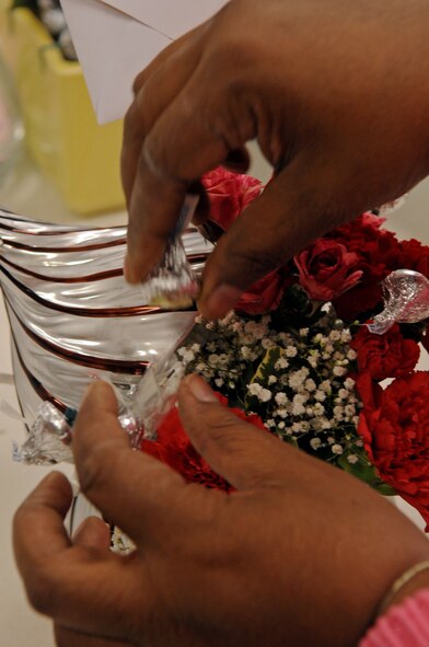 BARKSDALE AIR FORCE BASE, La. -- Mrs. Cheryl Williams, Barksdale's Pedals and Blooms Flower florist designer, prepares a floral arrangement in a Hershey's Kiss vase Feb. 15. Although the Floral shop prepared more than 300 arrangements for Valentine's Day the orders are still continuing to come in. Valentine's Day is one of the busiest days for the shop. (U.S. Air Force Photo/Senior Airman La'Shanette V. Garrett) (RELEASED)