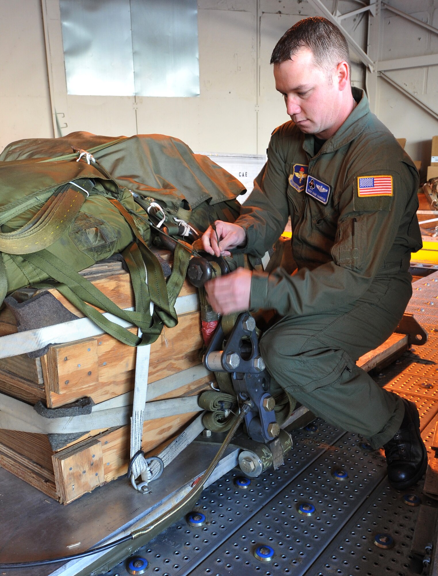Staff Sgt. Dave Sanders, a 62nd Airlift Squadron loadmaster, secures a heavy equipment pallet, at Little Rock Air Force Base, Ark., Feb. 14, 2011. As part of his pre-flight check Sergeant Sanders ensures the pallets and equipment are locked in place. (U.S. Air Force photo by Airman 1st Class Rusty Frank)