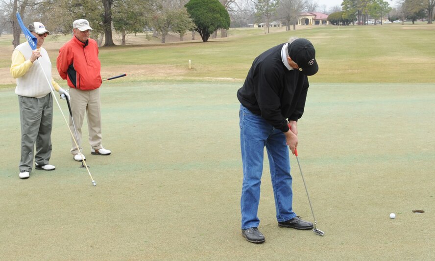 BARKSDALE AIR FORCE BASE, La. -- Walt Grabski putts on the green as his friends look on at the Fox Run golf course on Barksdale Air Force Base, La., Feb. 15. The golf course is open daily from 7 a.m. to dusk. It is a United States Golf Association regulated 18-hole course. (U.S. Air Force photo/Airman 1st Class Sean Martin)(RELEASED)