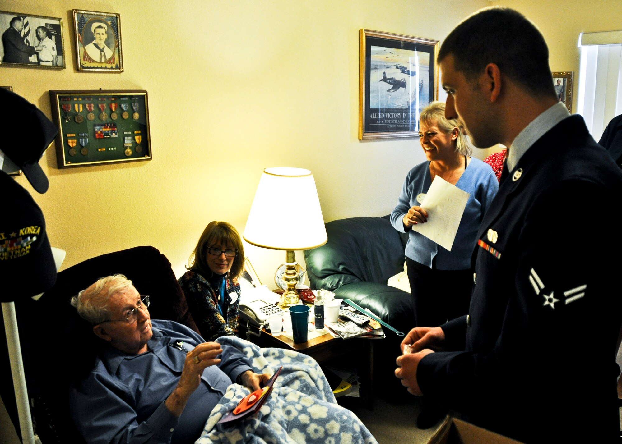 Airman 1st Class Noah Blach, 96th Communications Squadron, presents Valentine’s Day cards to Air Force veteran David Woods Feb. 14, during his visit to 'Wellington Place' in Fort Walton Beach, Fla.  Airman Blach joined more than 200 Eglin Airmen who presented homemade valentines and flowers to local retirement home residents.  (U.S. Air Force photo/Kevin Gaddie)